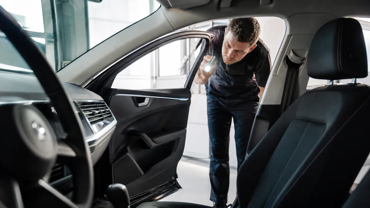 Intérieur d'une voiture avec le tableau de bord visible, portière ouverte
